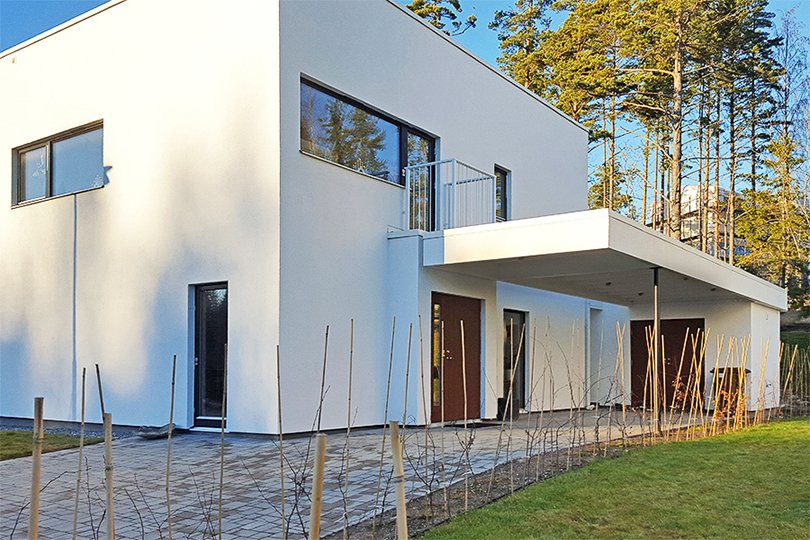 hvitt toetasjes privat hus med tre balkongdører og vinduer