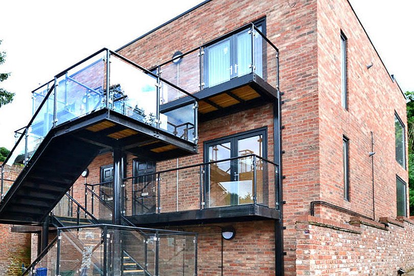 murstein kontorbygg med svarte balkongdører