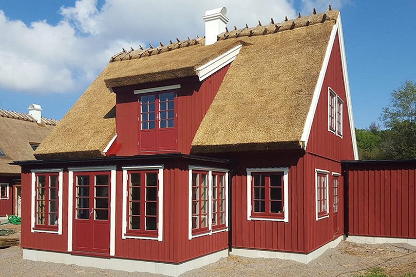 to-etasjes hus med matchende vinduer i rødt